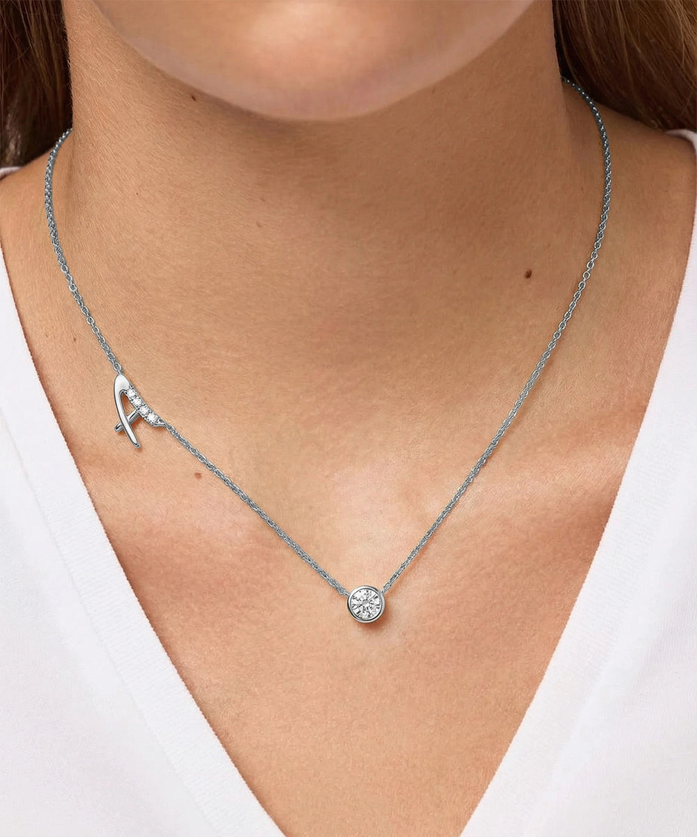 Necklace with a round pendant on a person wearing a white top
