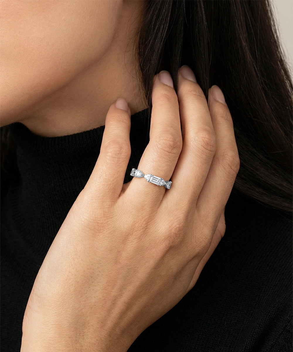 Close-up of a hand wearing a silver ring with a blurred background
