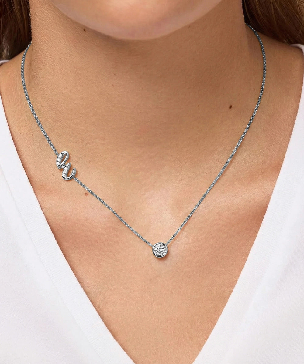 Silver necklace with a pendant on a person wearing a white top