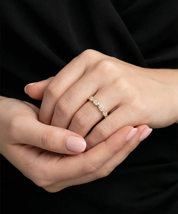 Close-up of hands with a diamond ring on a black background