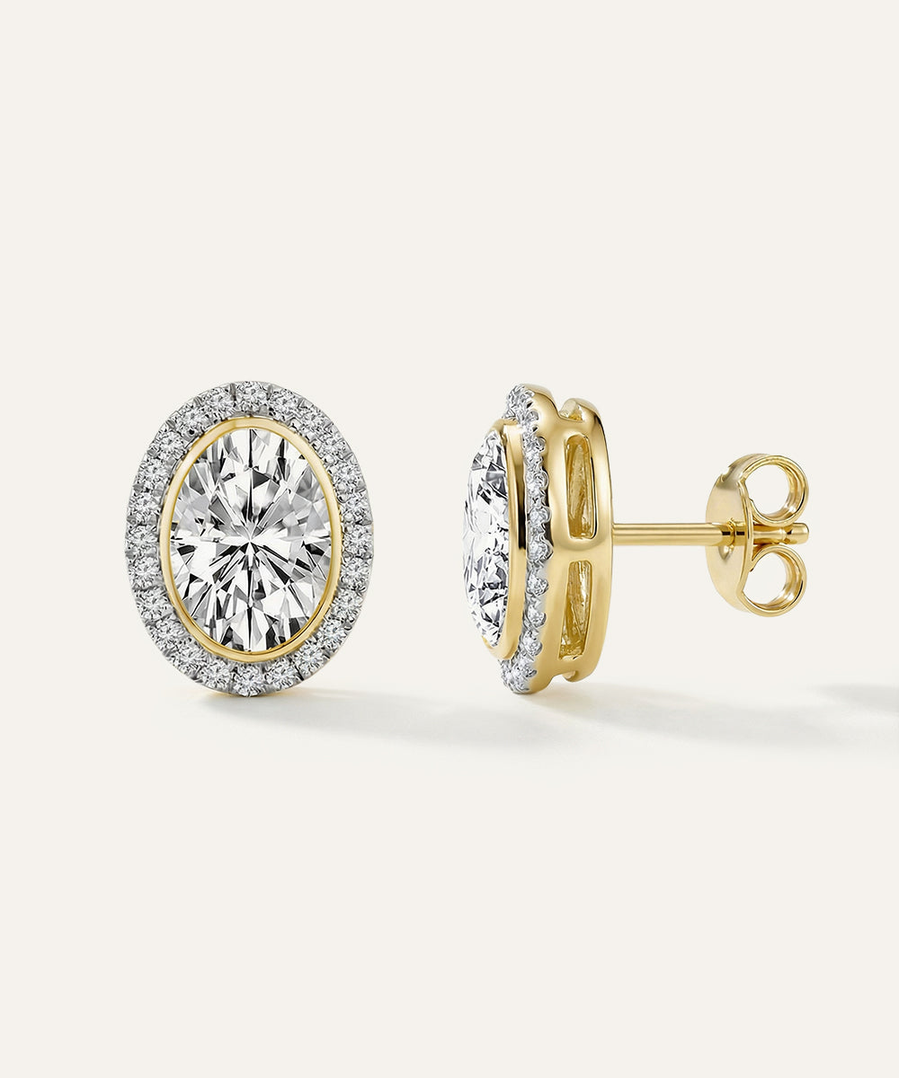 Gold earrings with diamond-like stones on a white background
