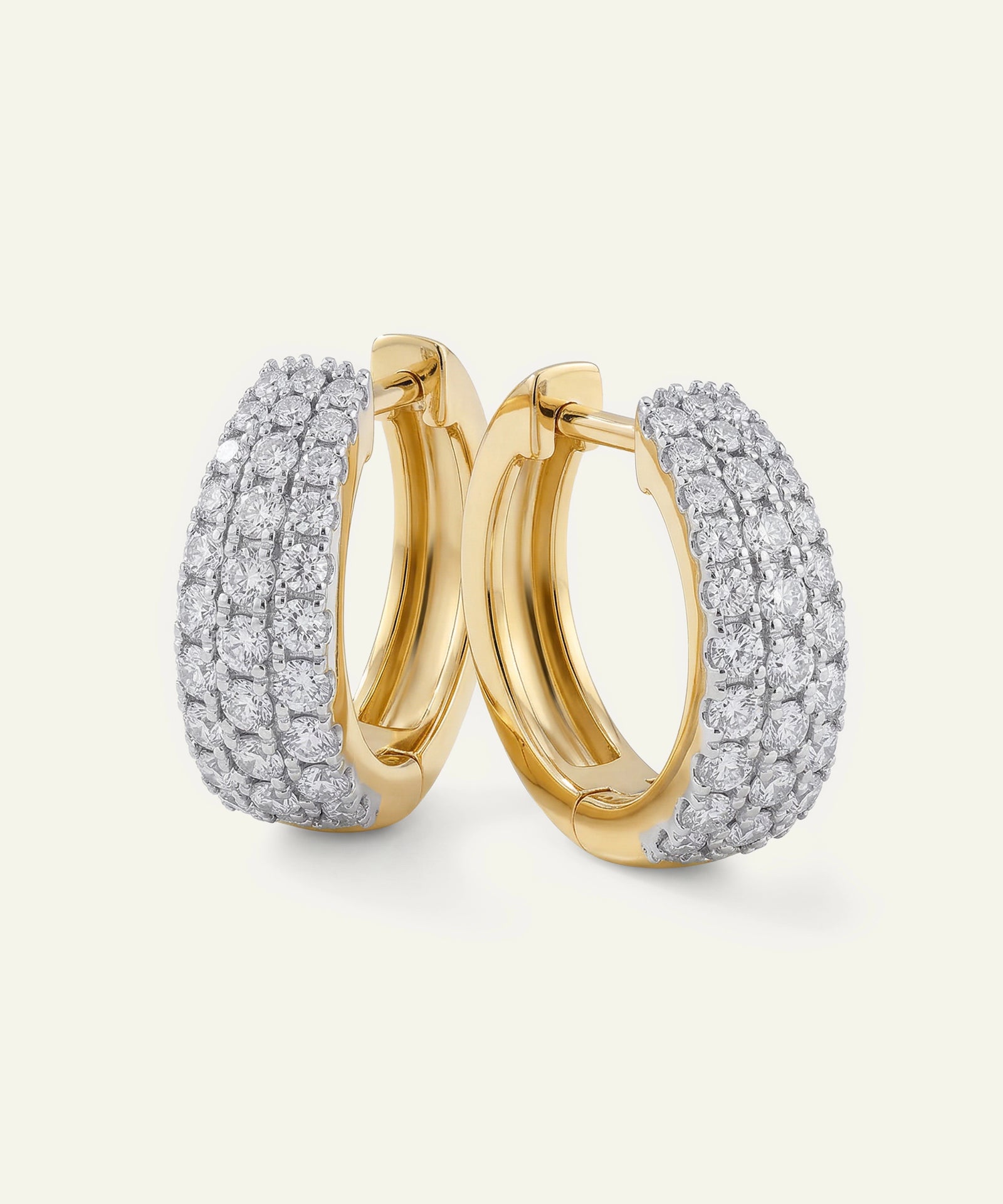 Pair of gold hoop earrings with diamond accents on a light gray background