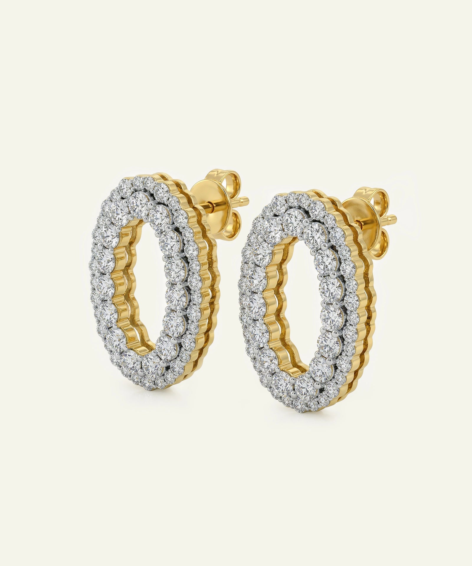 Gold and silver hoop earrings on a light beige background