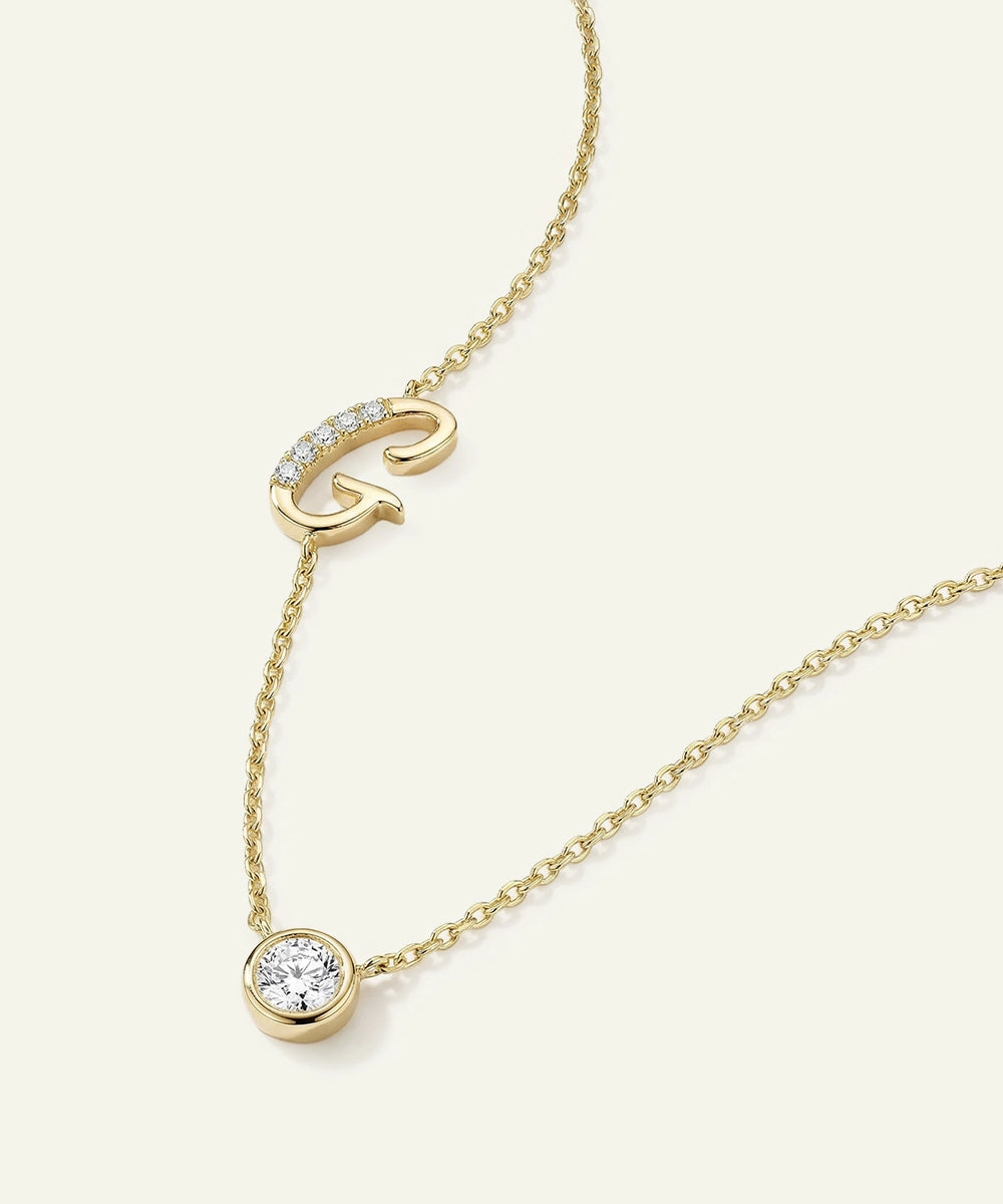 Gold necklace with a letter 'G' pendant on a white background