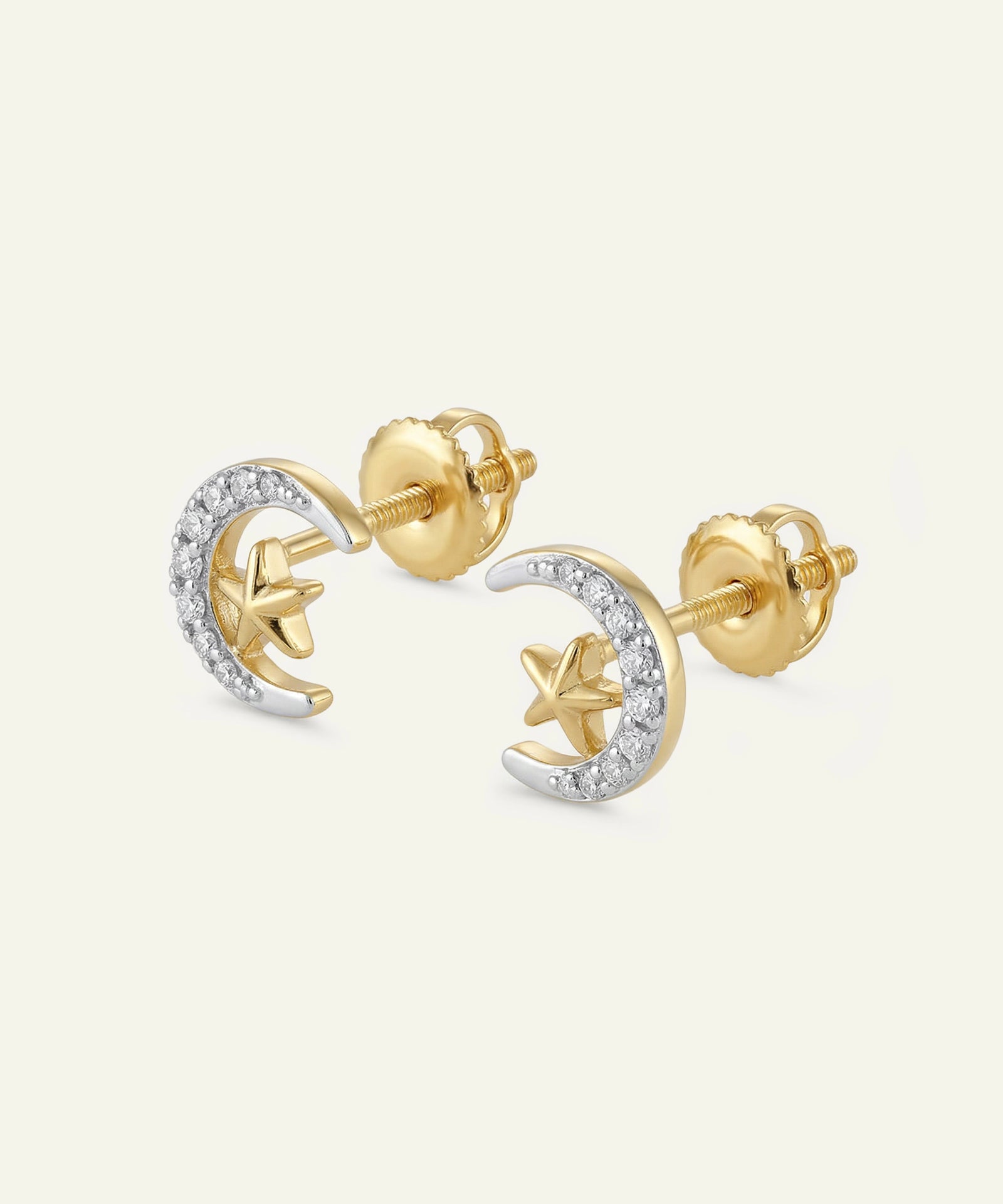 Gold earrings with star and moon designs on a white background