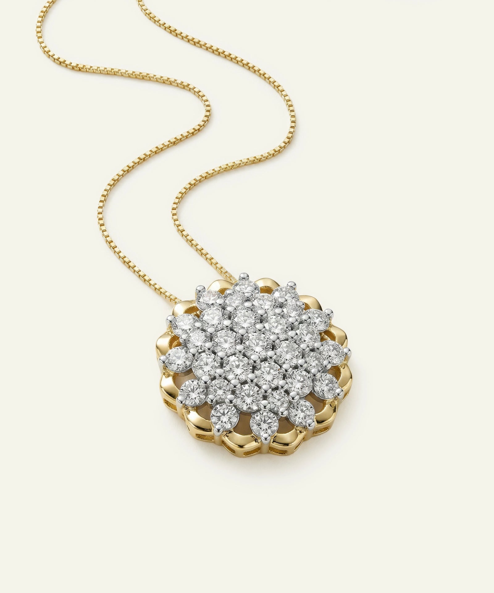 Gold necklace with a diamond pendant on a light beige background