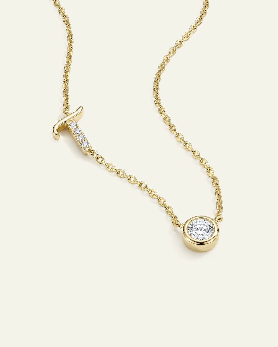 Gold necklace with a diamond pendant on a light beige background