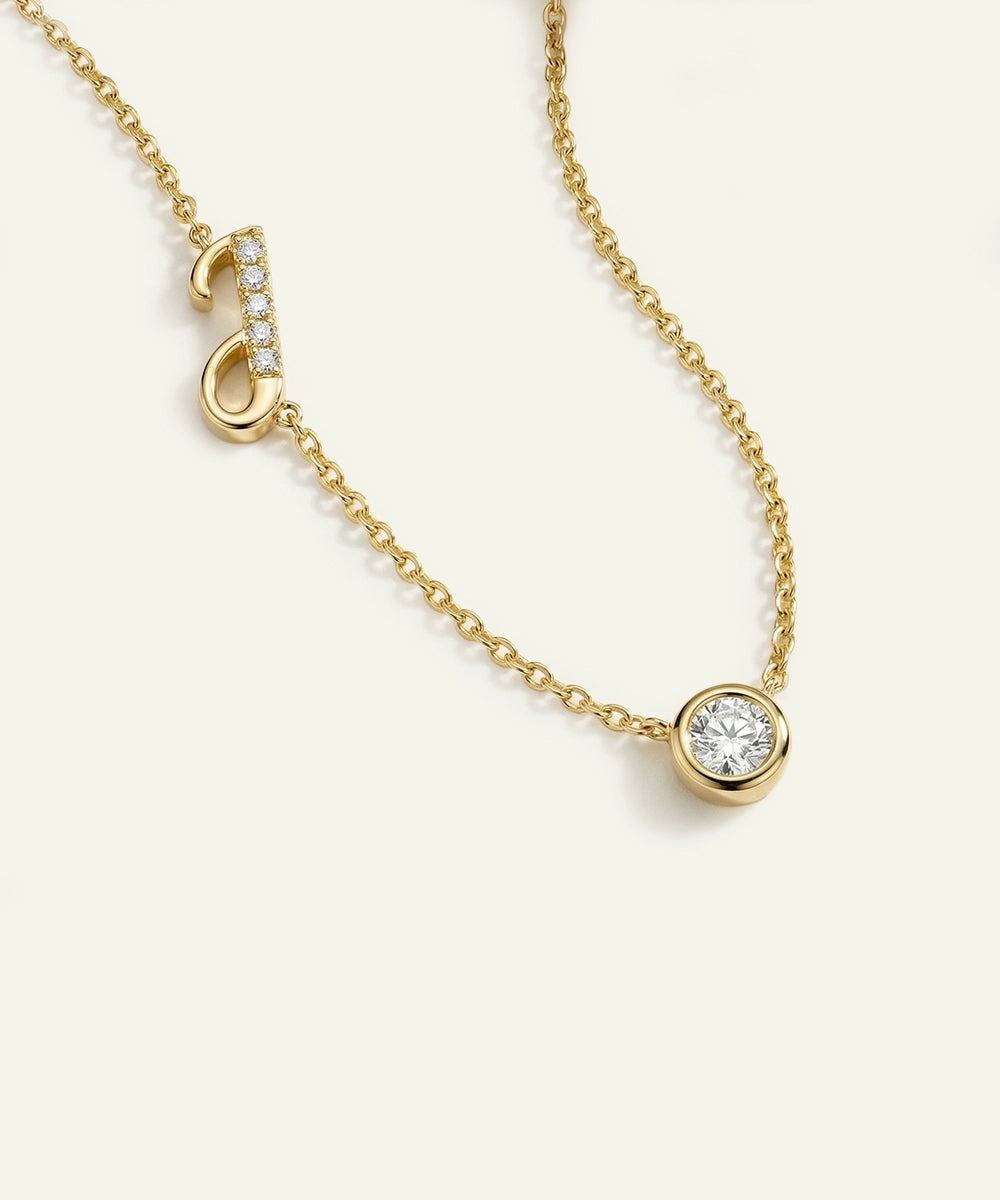 Gold necklace with a diamond pendant on a light beige background