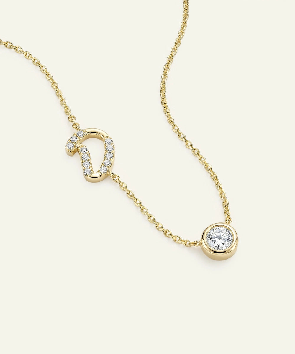 Gold necklace with diamond pendant on a light beige background
