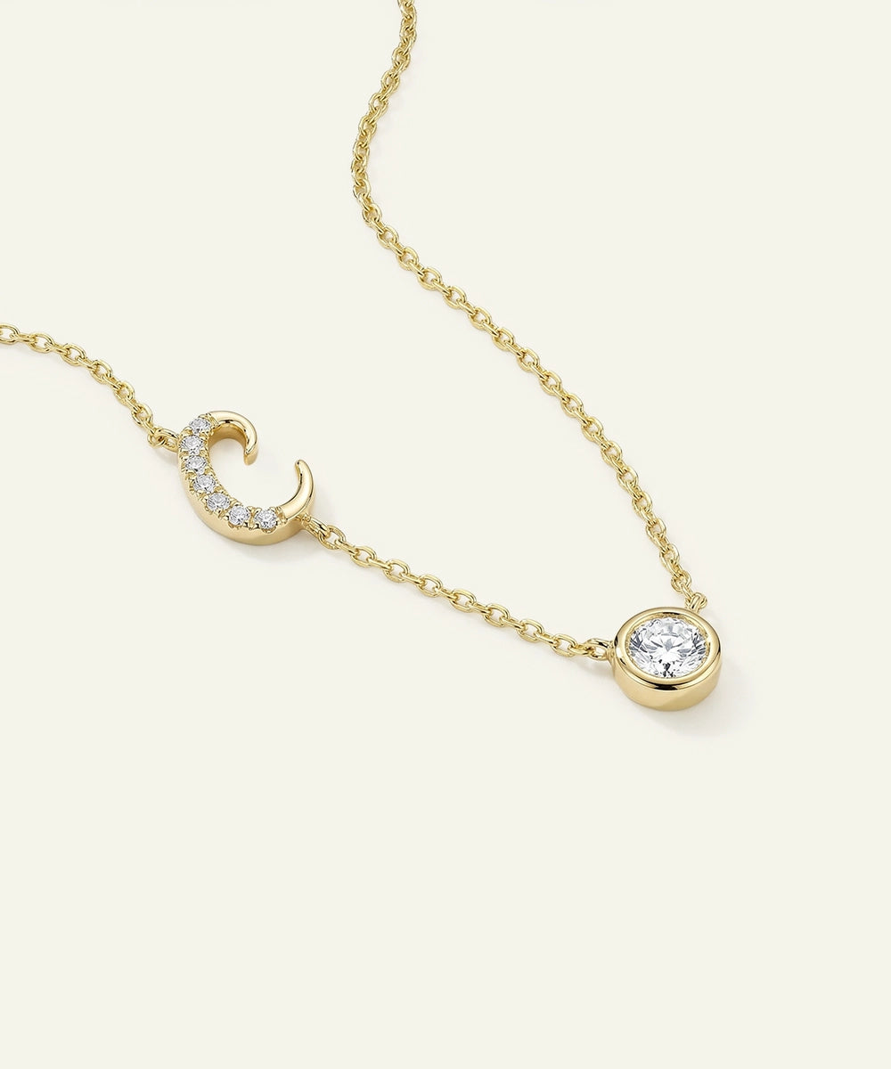 Gold necklace with diamond pendants on a light beige background