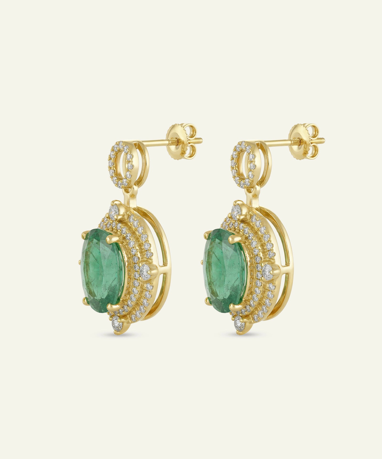 Gold earrings with green gemstones on a white background