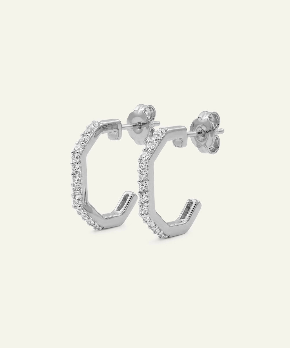 Silver hoop earrings with small diamonds on a light gray background