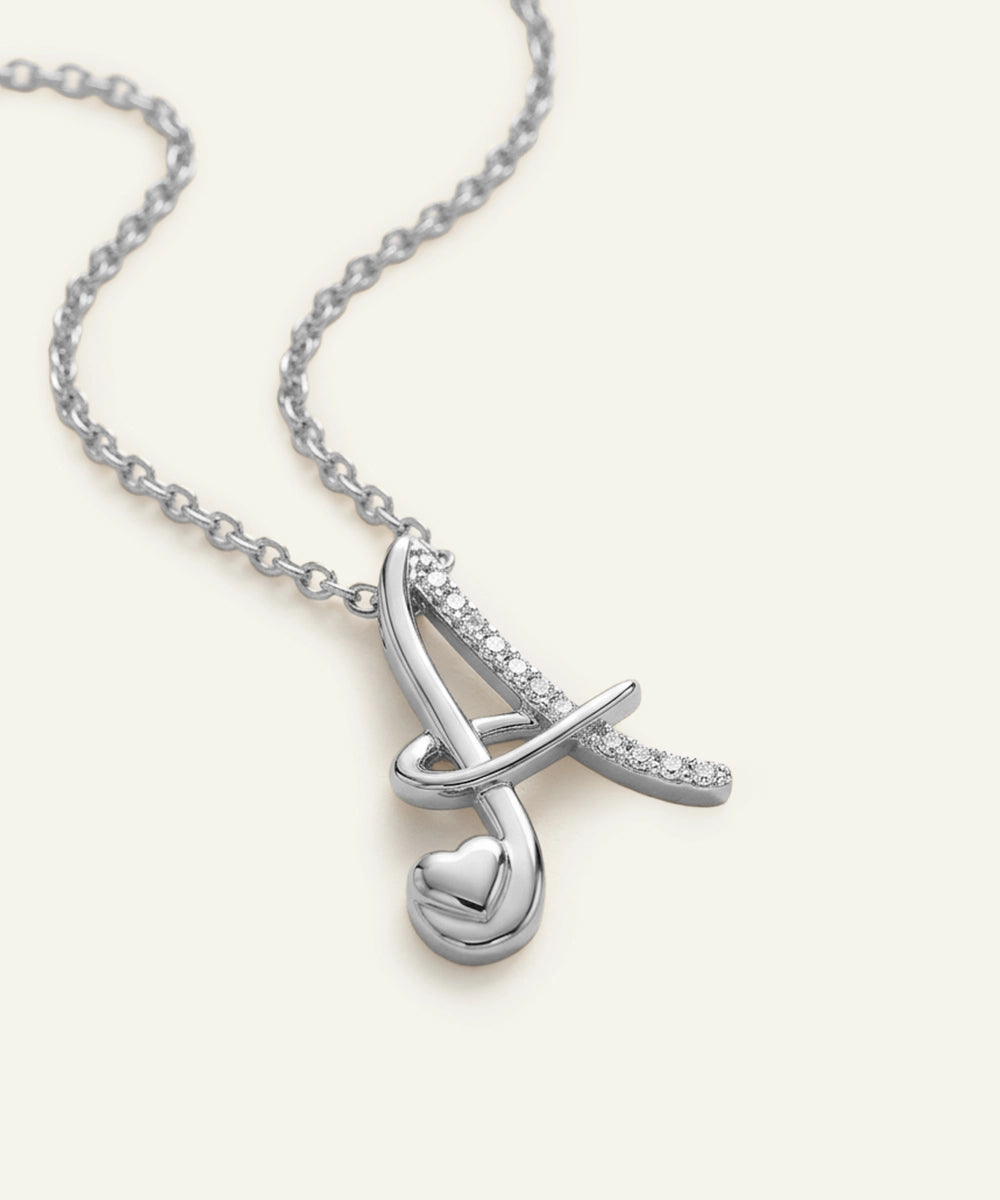 Silver necklace with a heart-shaped pendant on a white background
