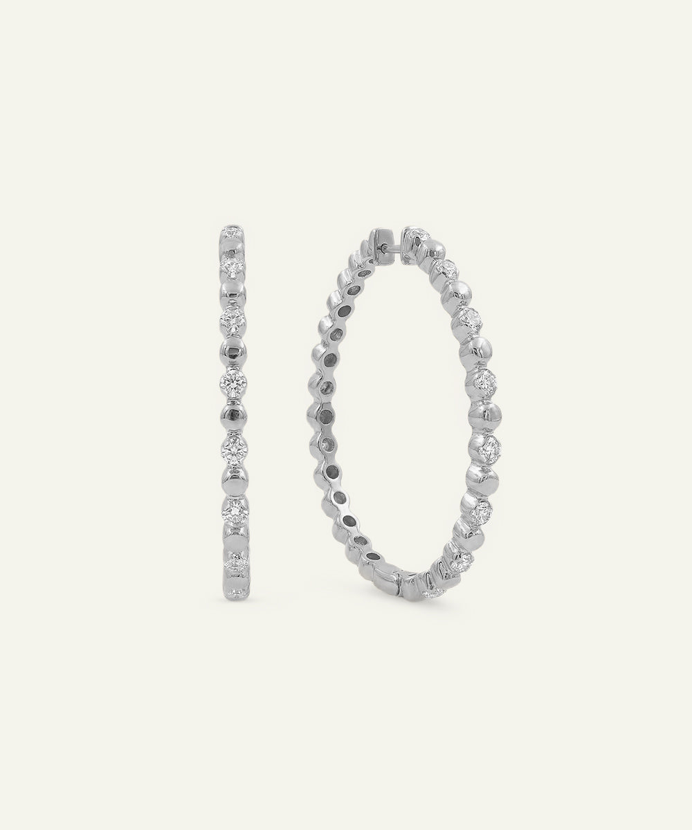 Pair of silver hoop earrings on a light gray background