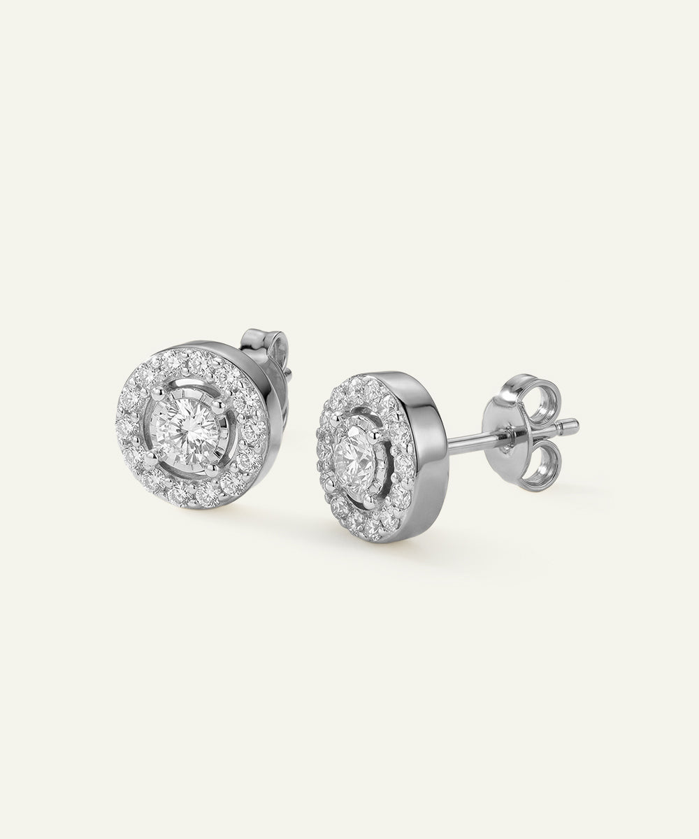Pair of silver earrings with clear gemstones on a white background
