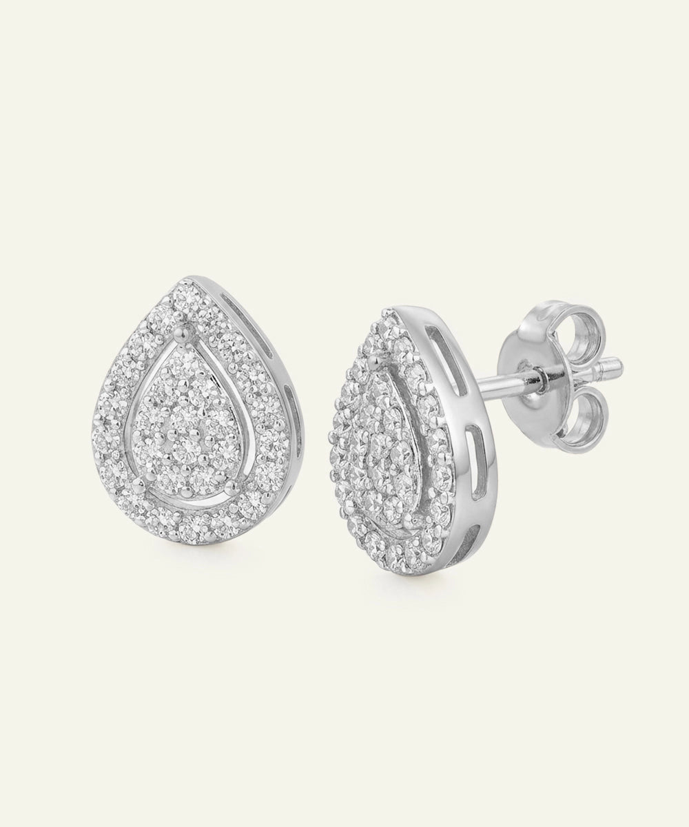 Pair of silver teardrop-shaped earrings with clear gemstones on a white background