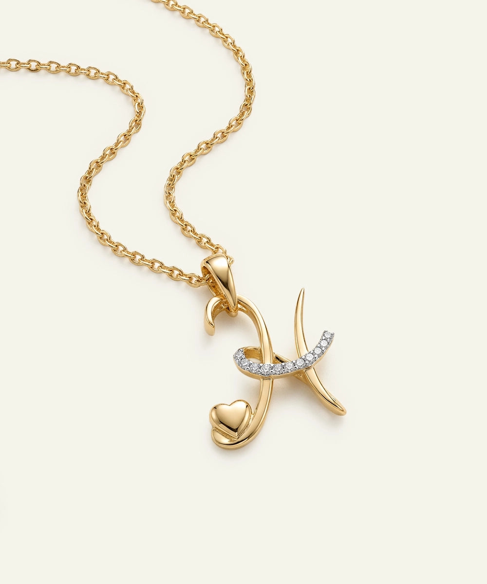 Gold necklace with a heart and curved design pendant on a light beige background