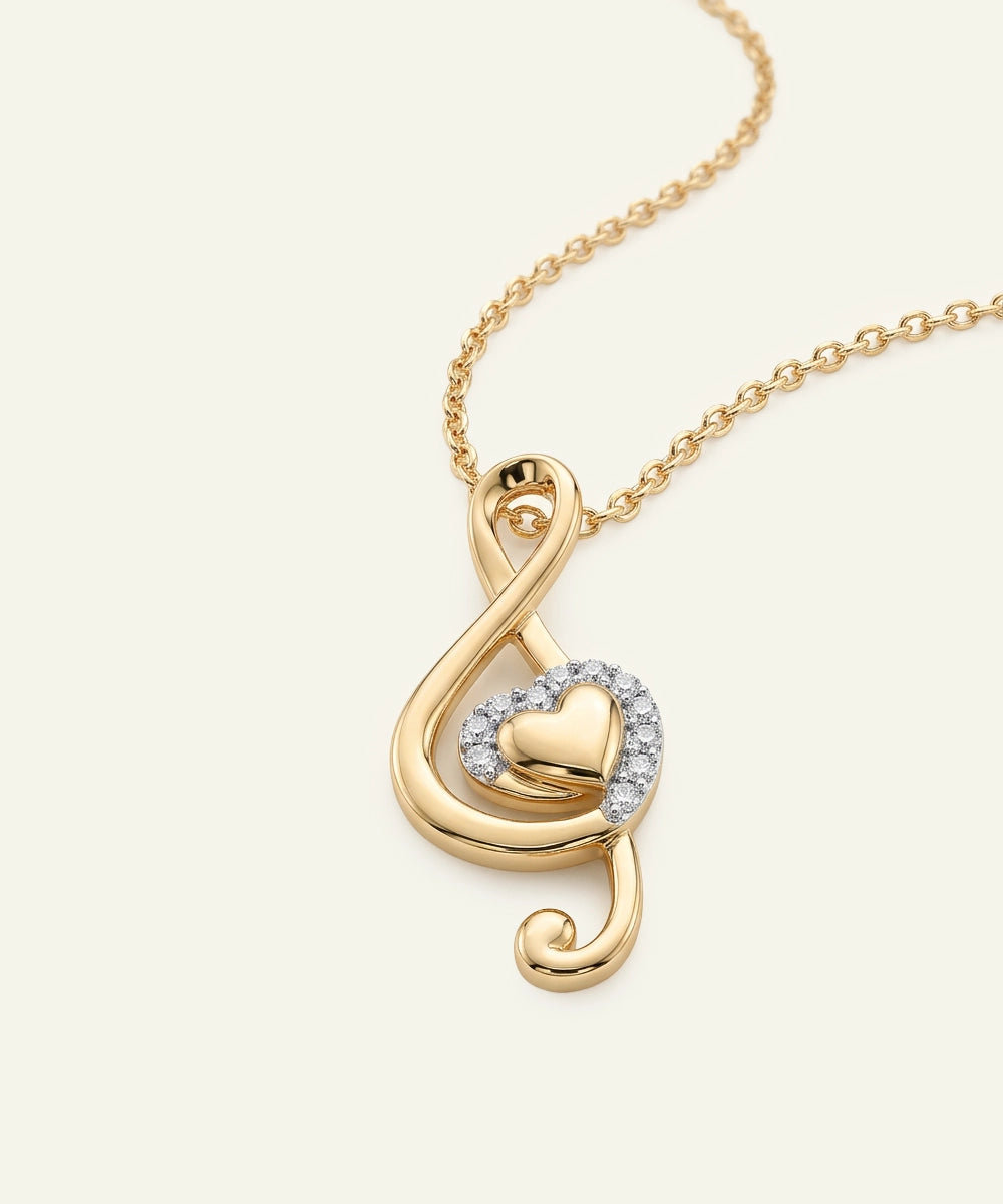 Gold necklace with a heart-shaped pendant on a white background