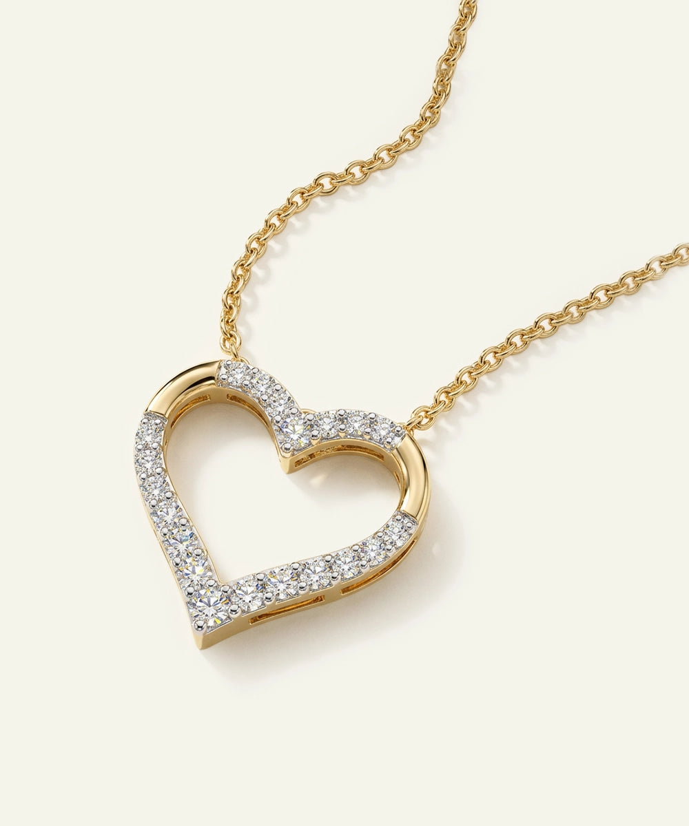 Gold heart-shaped necklace with diamonds on a white background