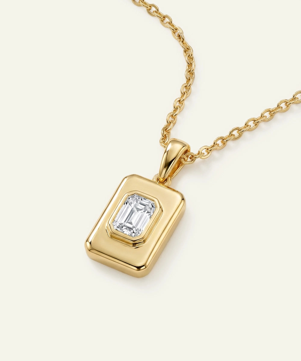 Gold pendant with a diamond on a white background