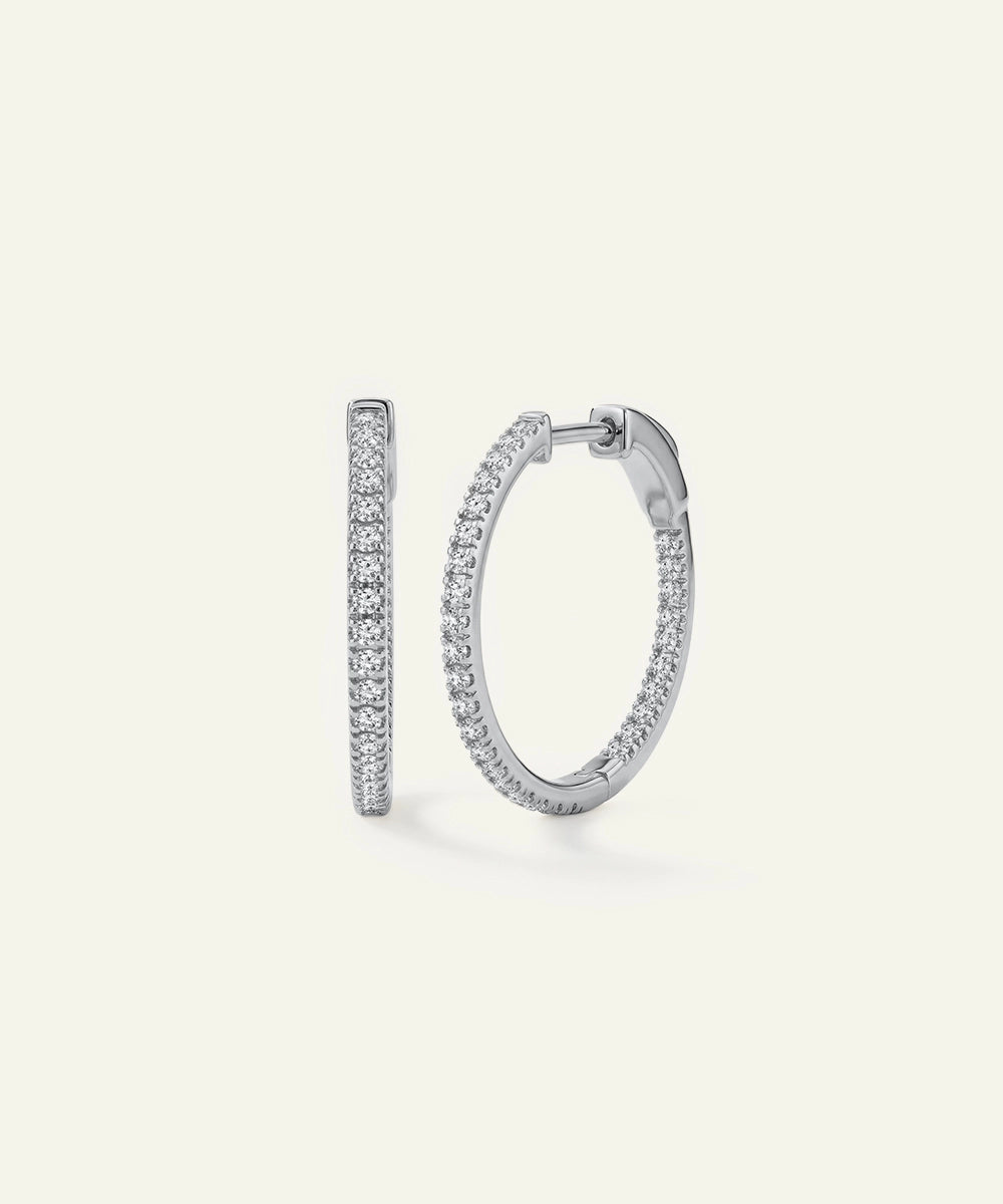 Pair of silver hoop earrings on a light gray background