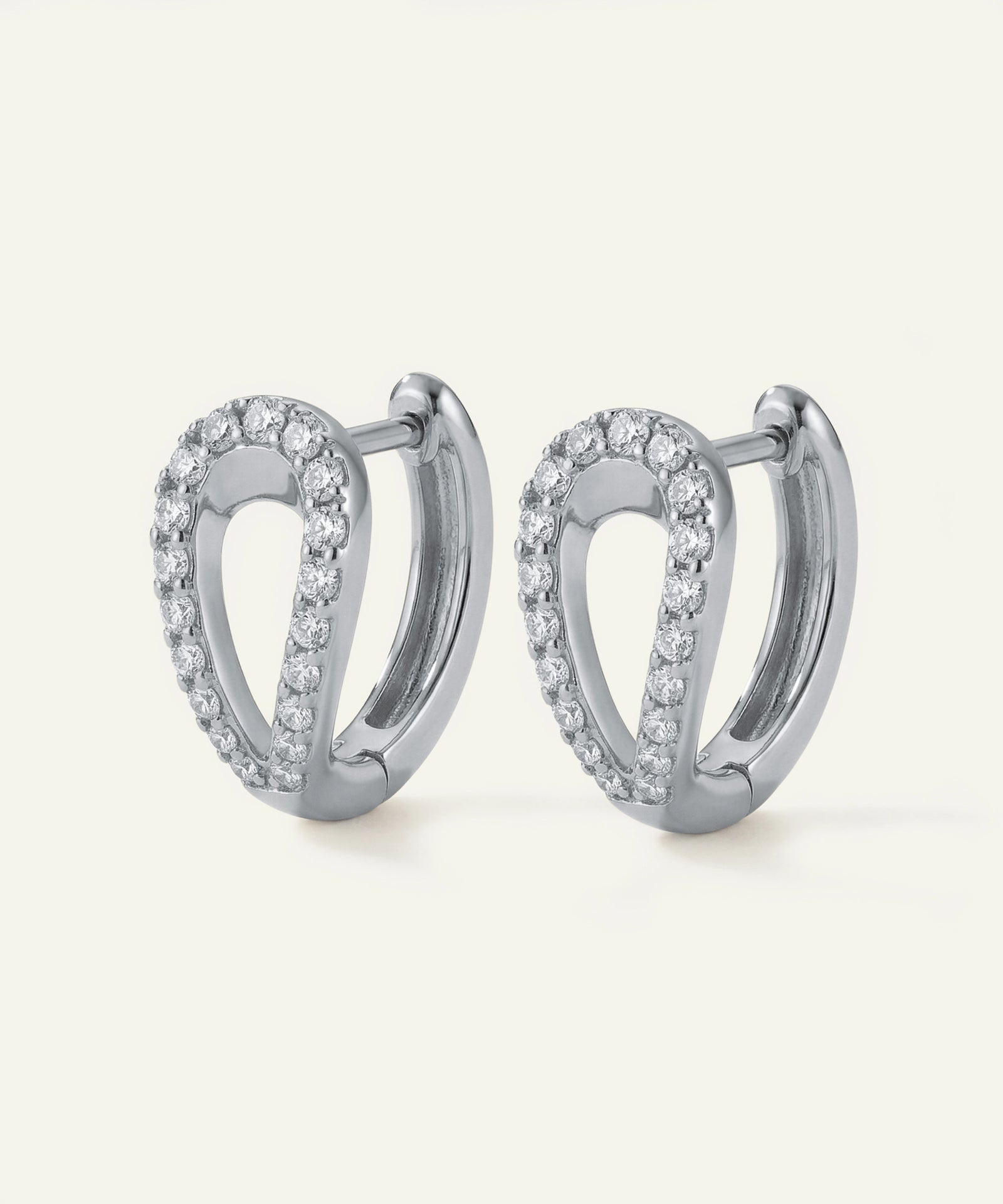 Pair of silver hoop earrings with clear stones on a white background