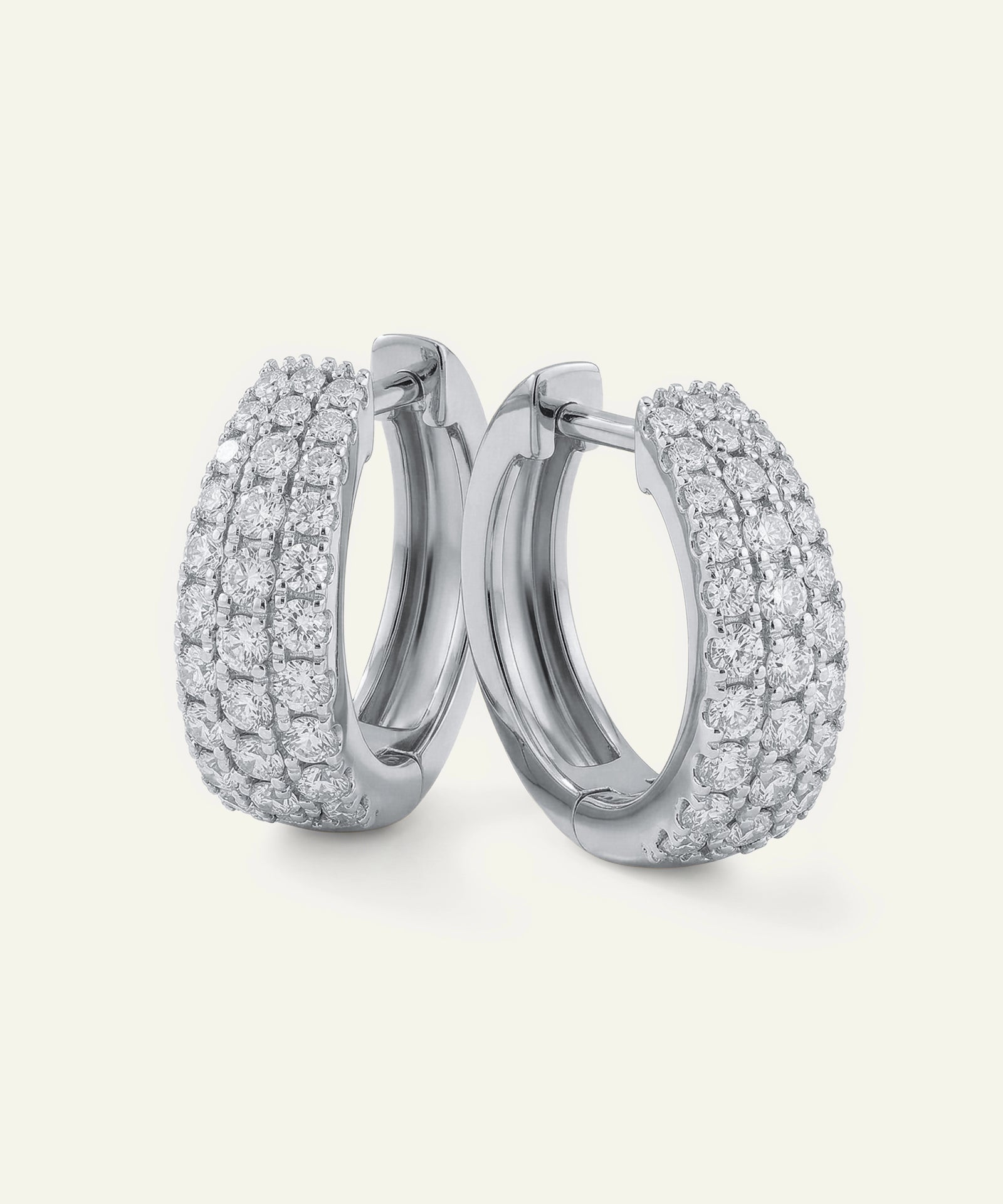 Pair of silver hoop earrings with diamond accents on a white background