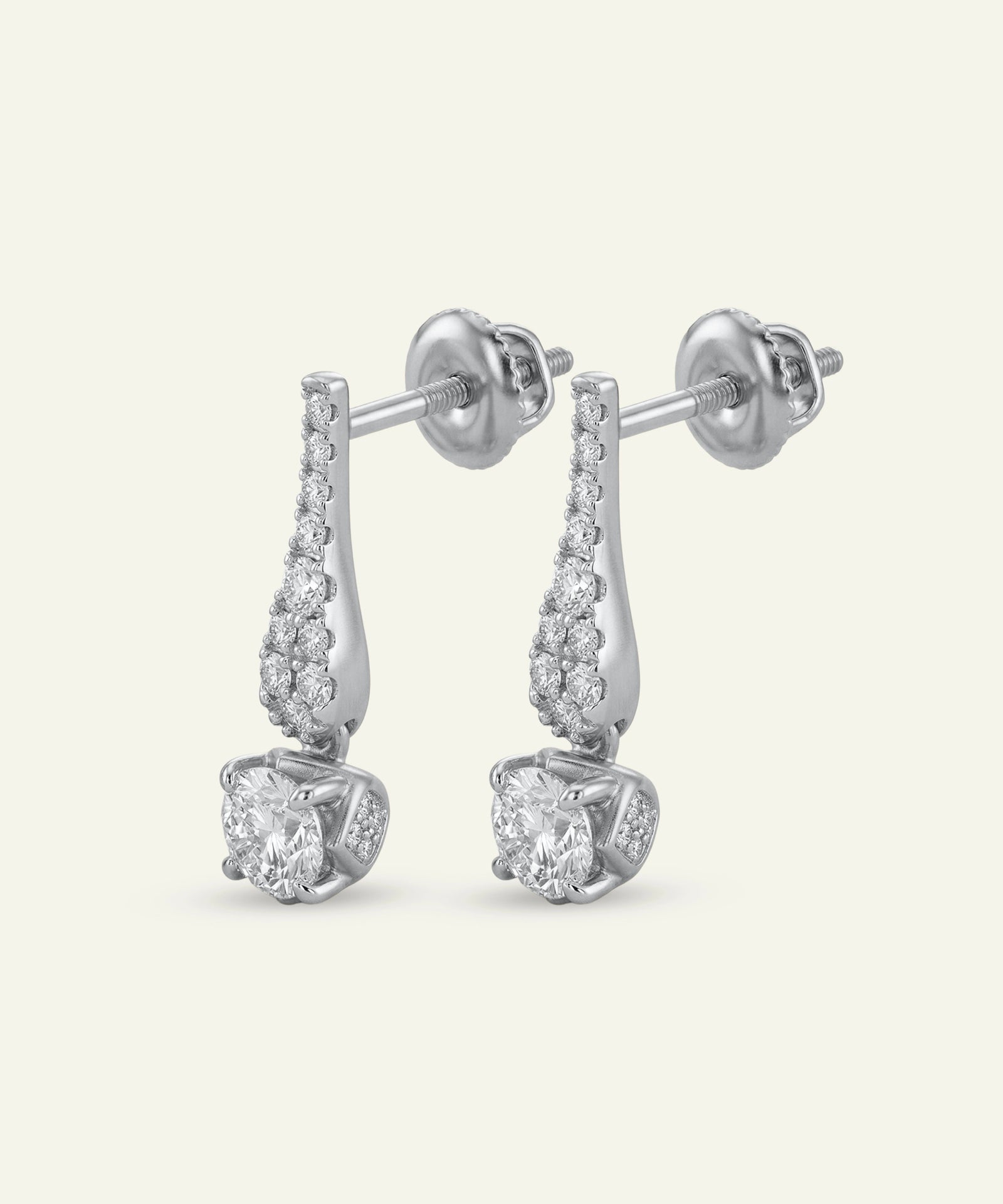Pair of silver earrings with clear gemstones on a white background