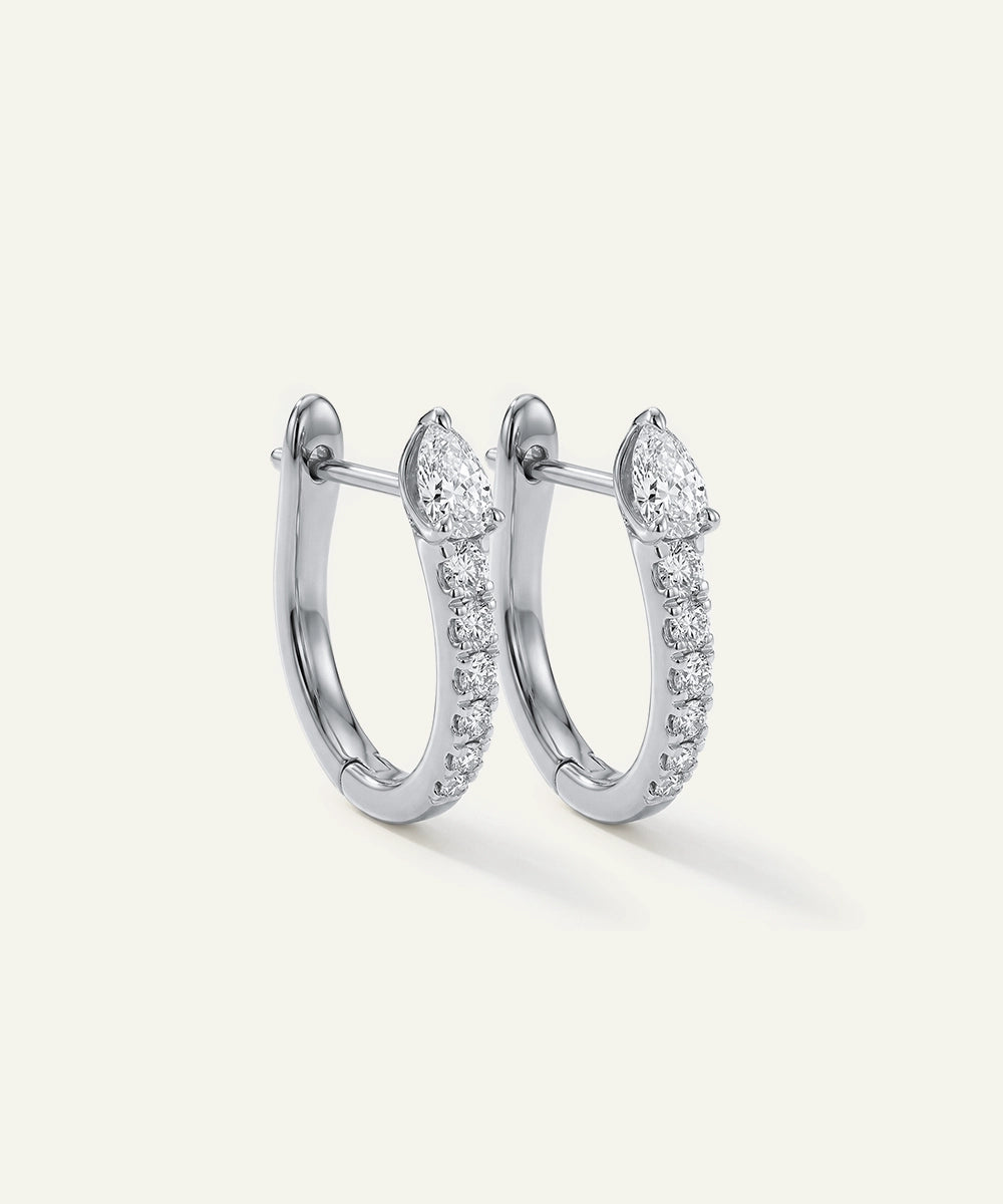 Pair of silver hoop earrings with clear gemstones on a white background