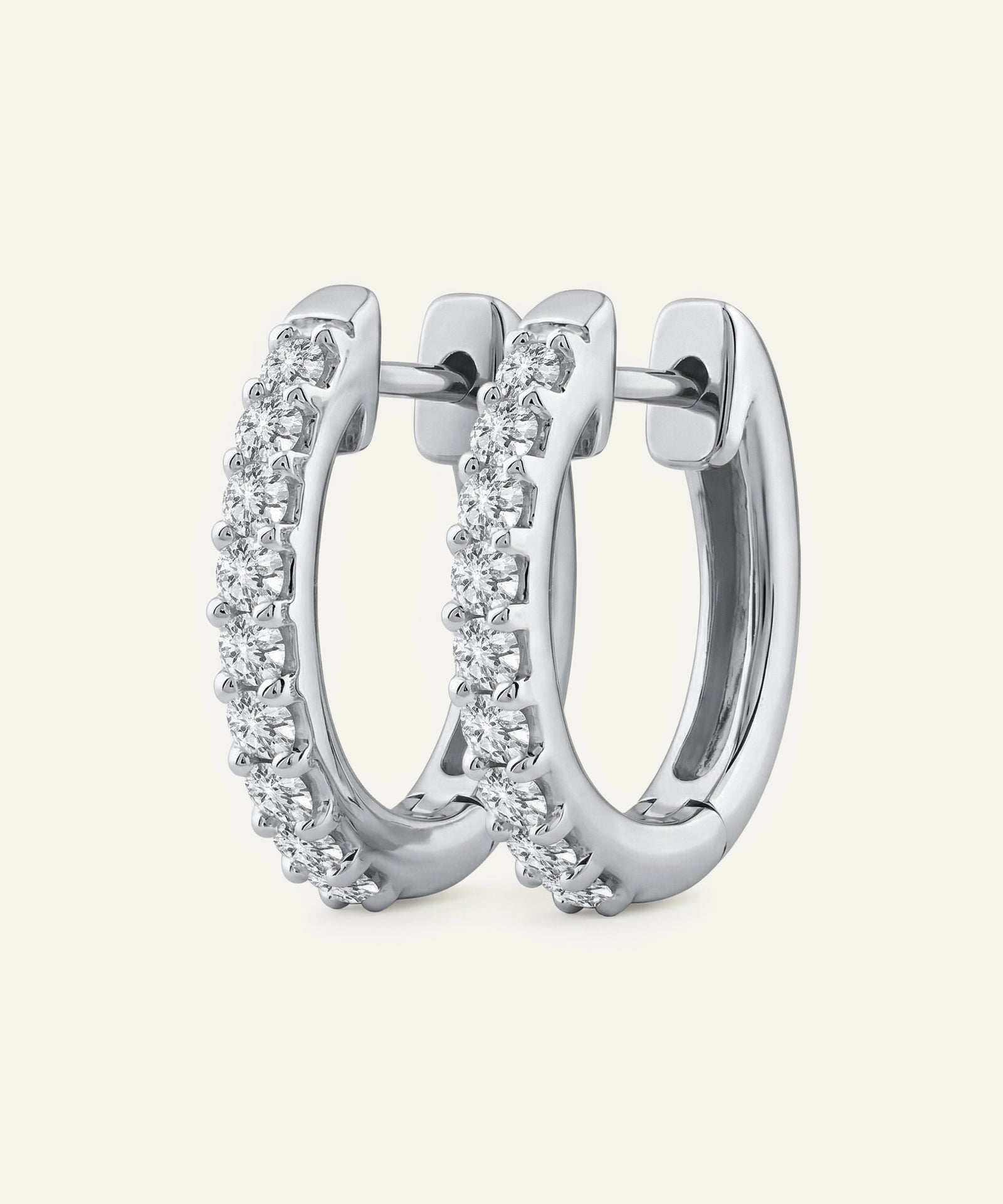 Silver hoop earrings with clear gemstones on a light gray background