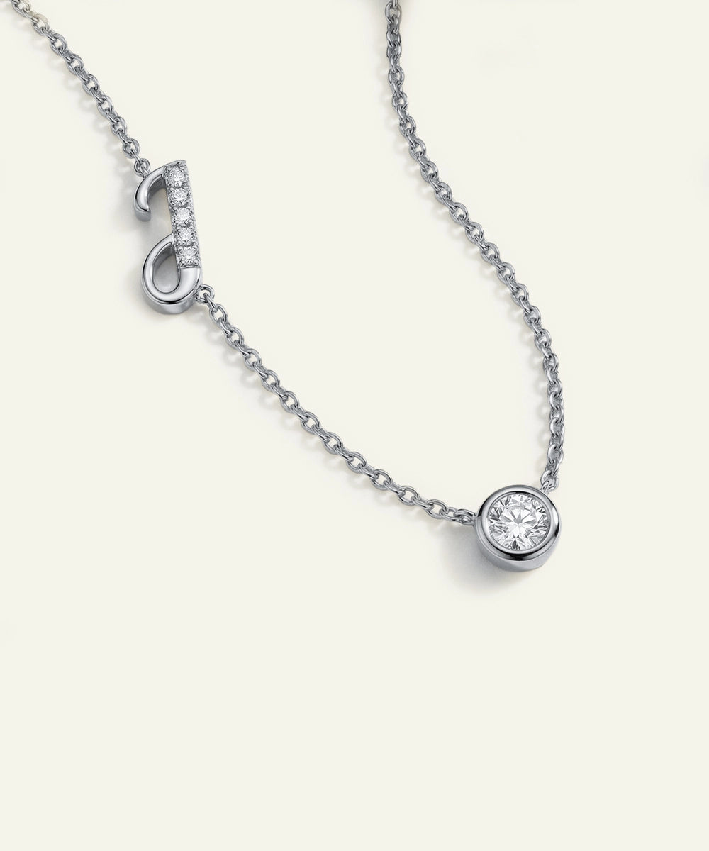 Silver necklace with a round pendant on a white background