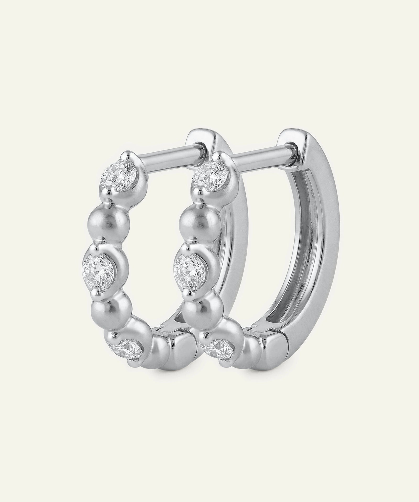 Silver hoop earring with small diamonds on a white background