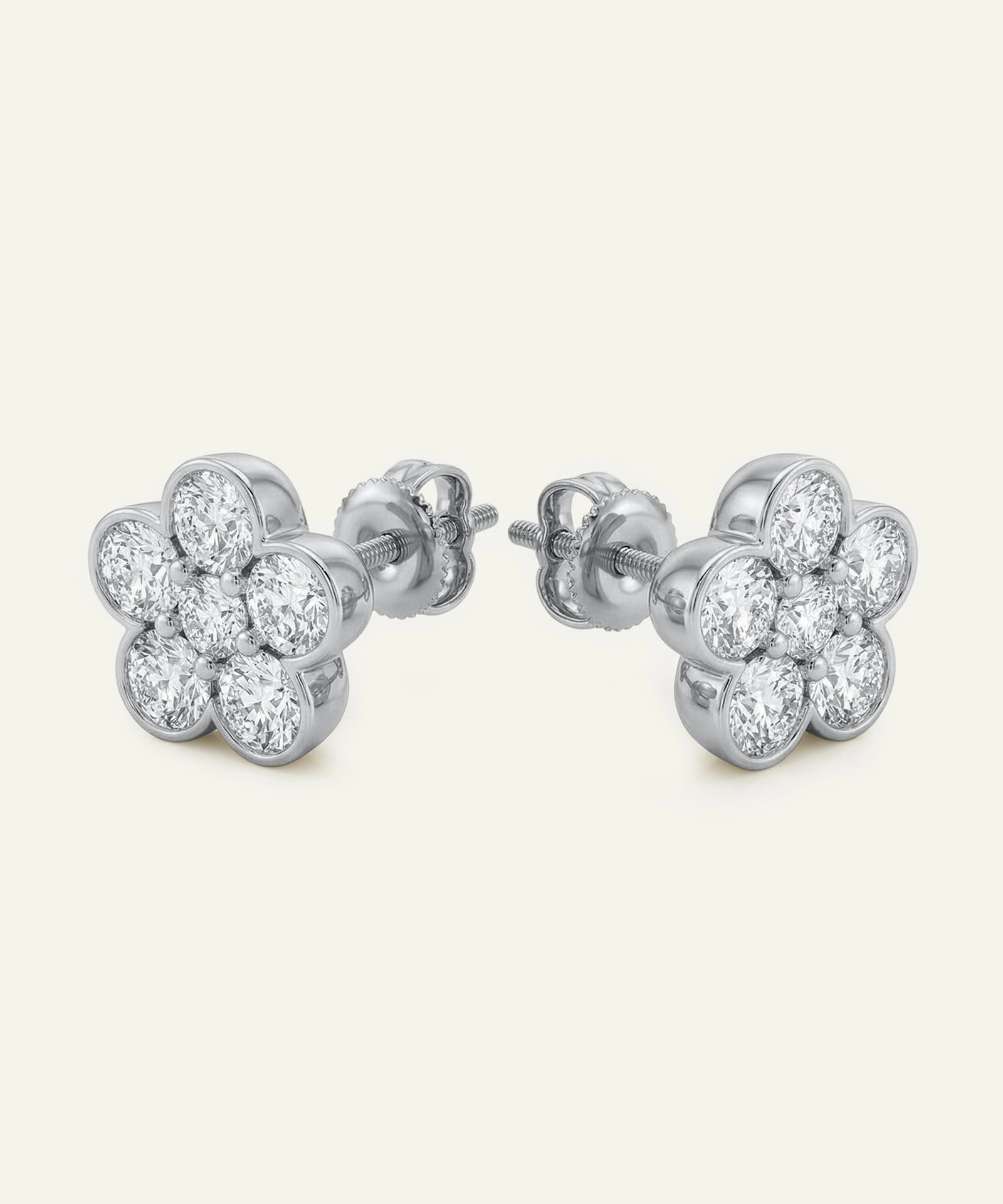Pair of silver flower-shaped earrings with clear gemstones on a white background
