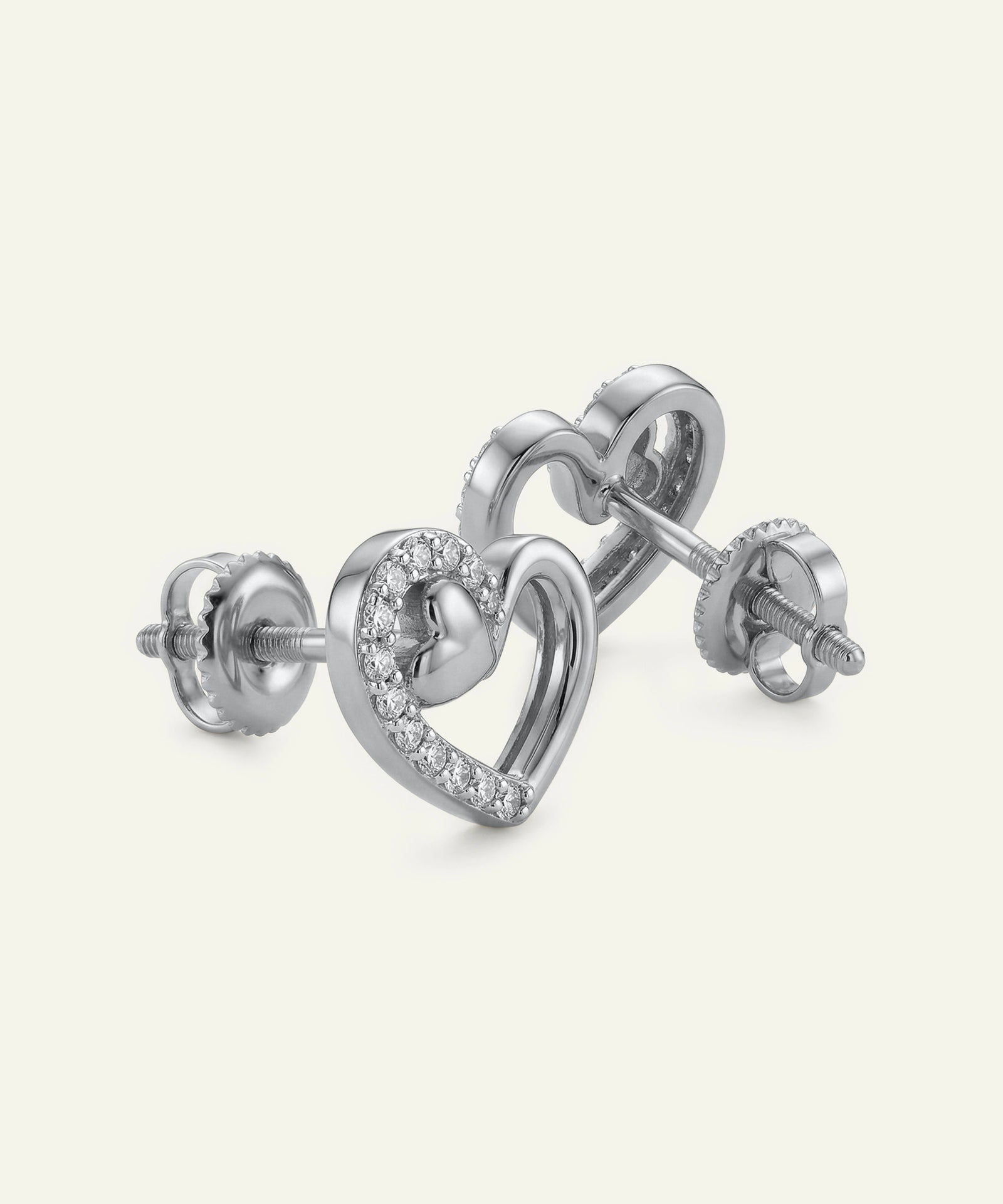 Heart-shaped silver earrings with small diamonds on a white background