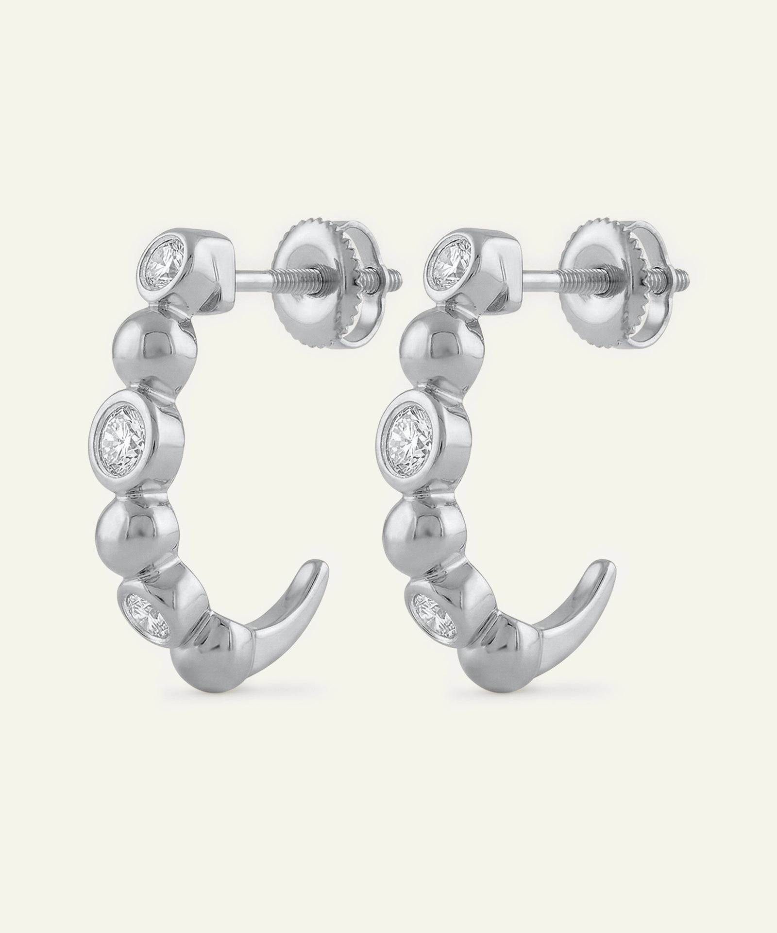 Silver hoop earrings with small diamonds on a white background