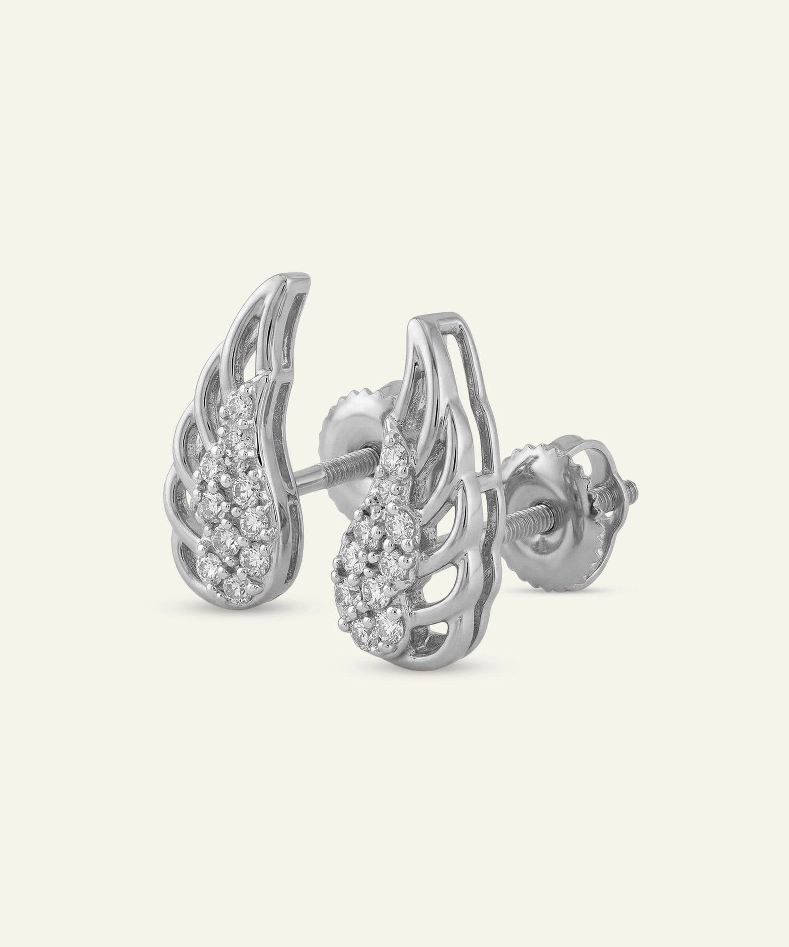 Silver wing-shaped earrings with small diamonds on a light gray background
