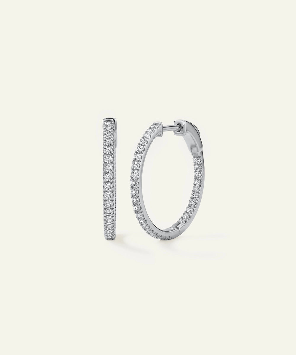 Pair of silver hoop earrings on a light gray background