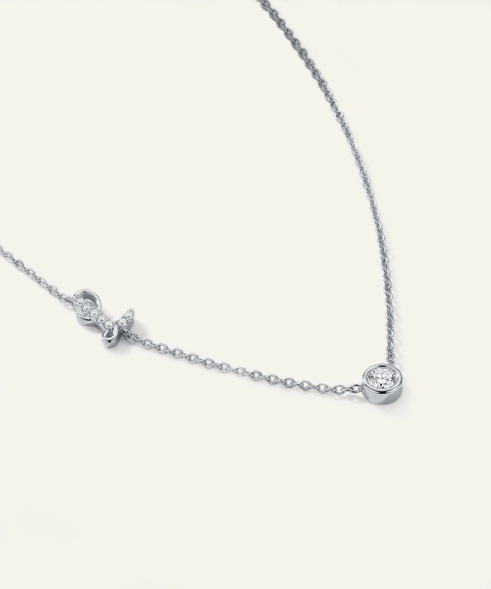Silver necklace with bow and round pendants on a white background