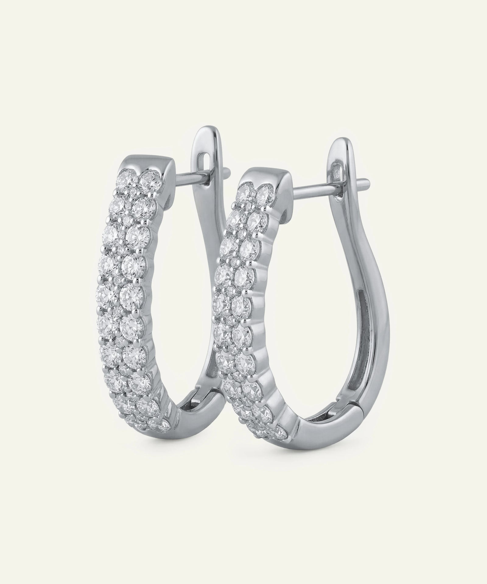 Silver hoop earrings with clear gemstones on a light gray background