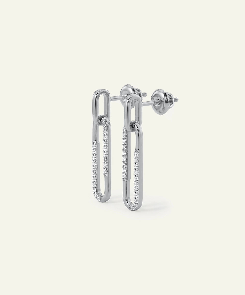 Silver hoop earrings with embedded stones on a light gray background