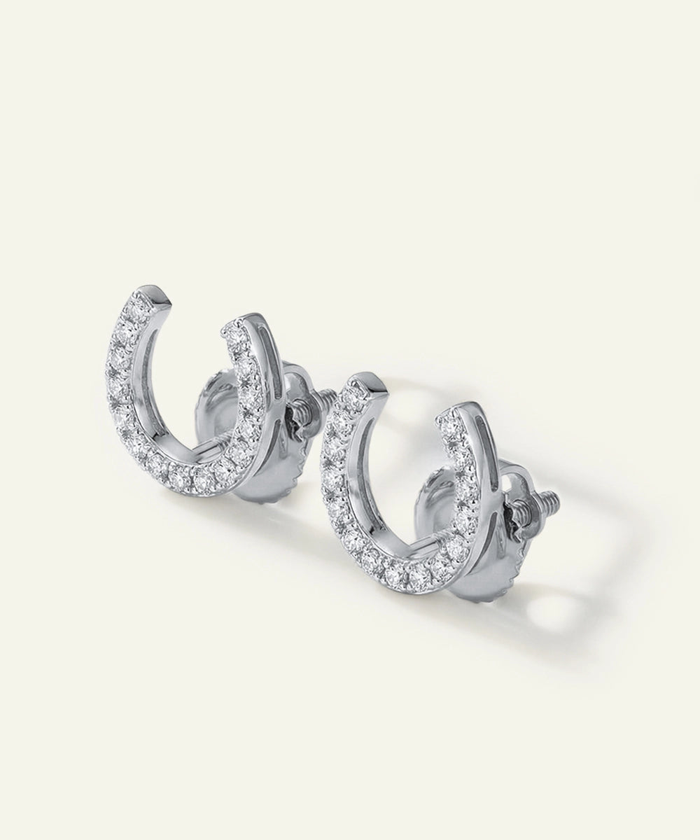 Silver hoop earrings with clear gemstones on a white background
