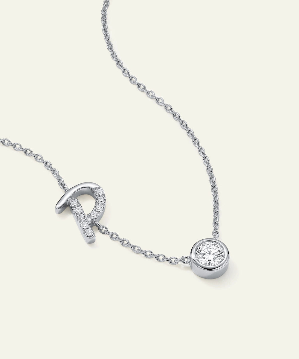 Silver necklace with a round pendant on a white background