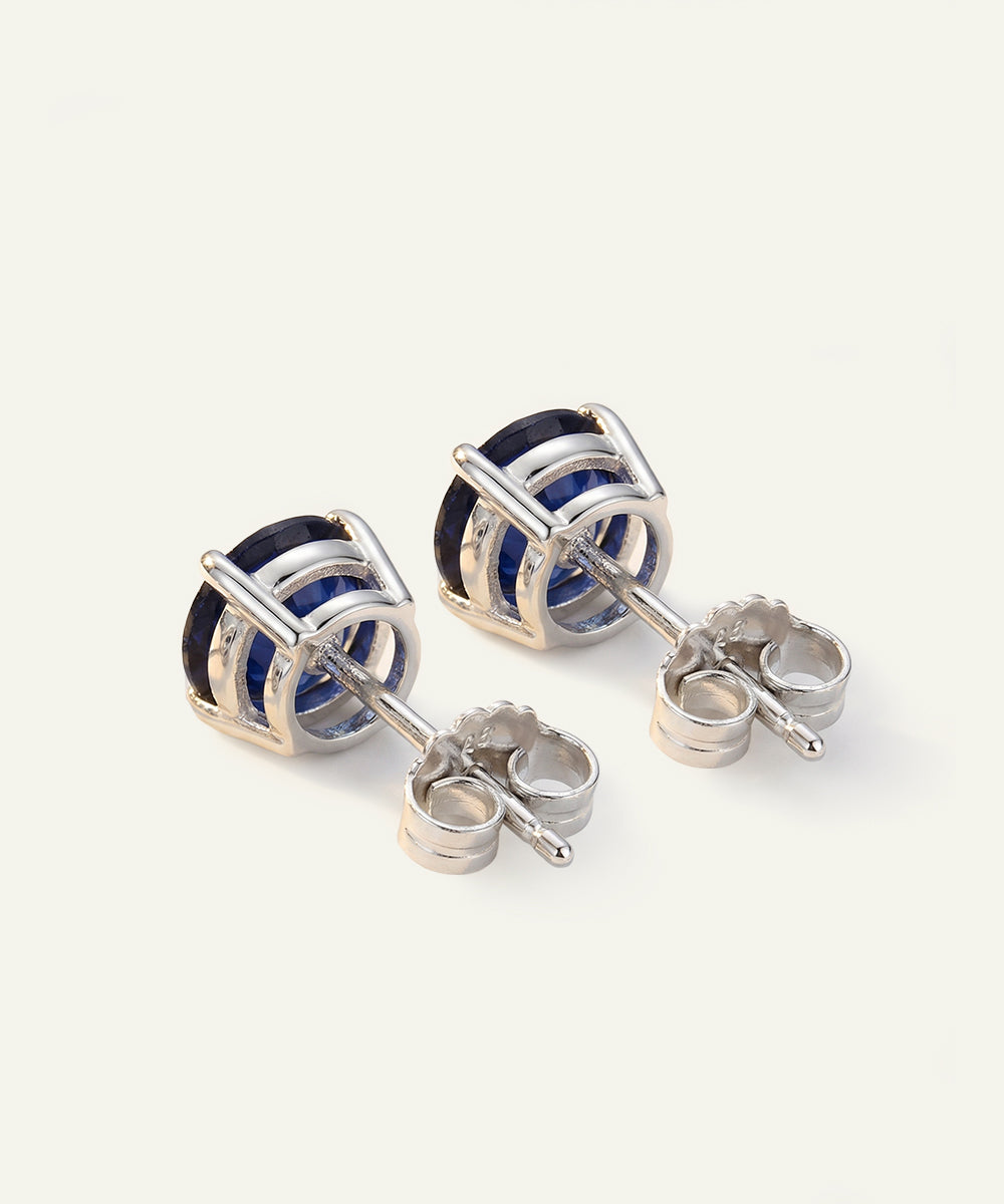Silver earrings with blue gemstones on a white background