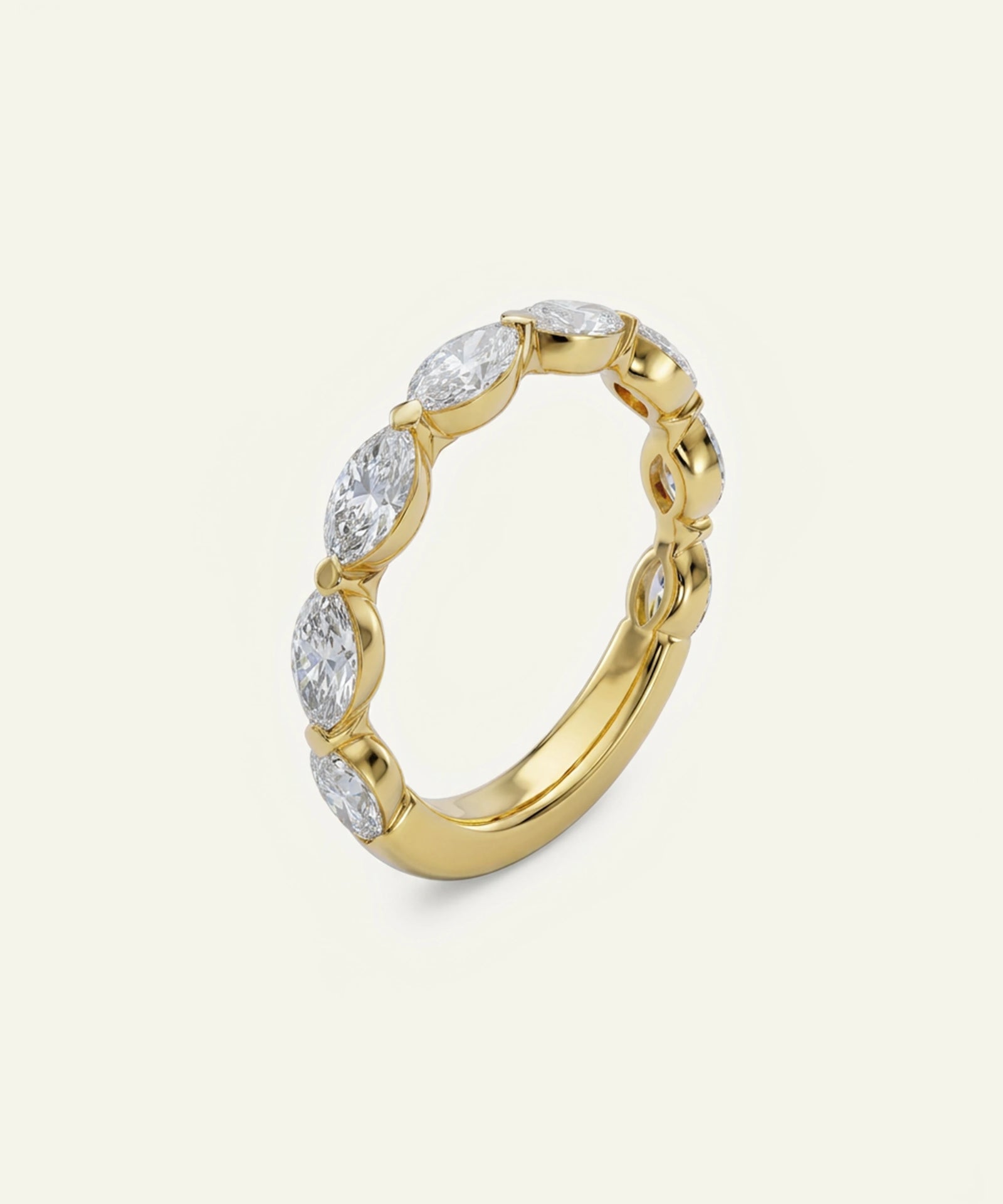 A yellow gold eternity ring featuring marquise-cut clear gemstones set in a continuous band, photographed on a clean, solid off-white background.