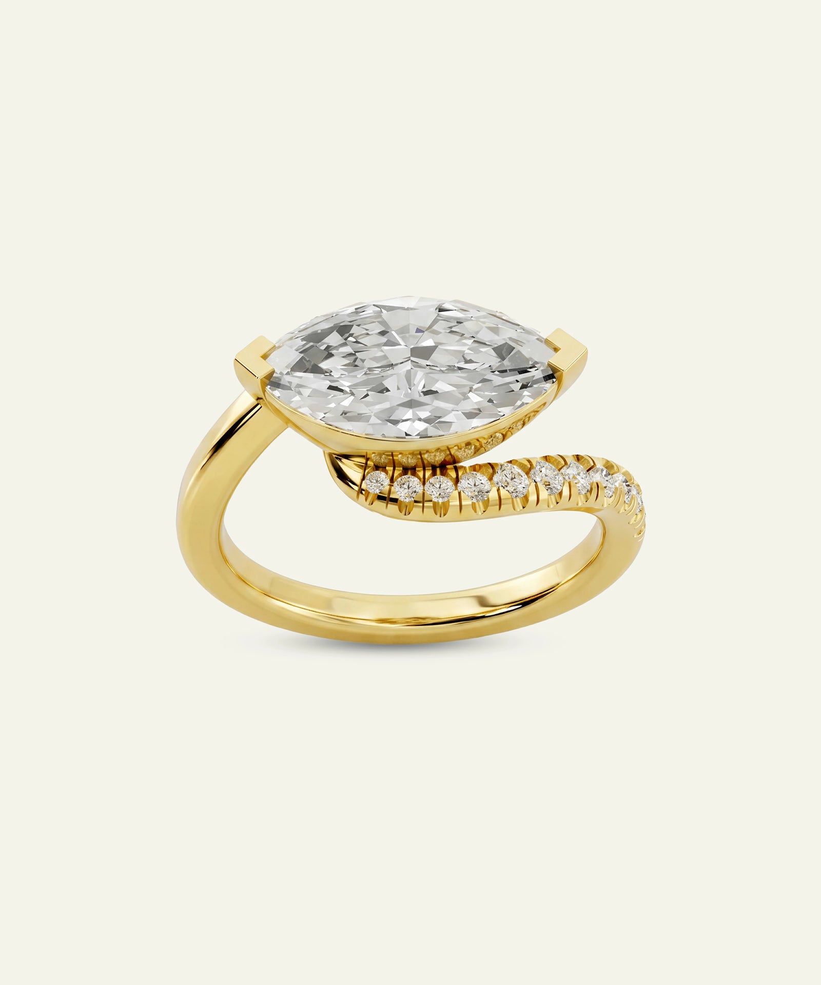 A yellow gold ring featuring a large marquise-cut clear diamond center stone and a curved pavé band with small diamonds, set against a light cream background.