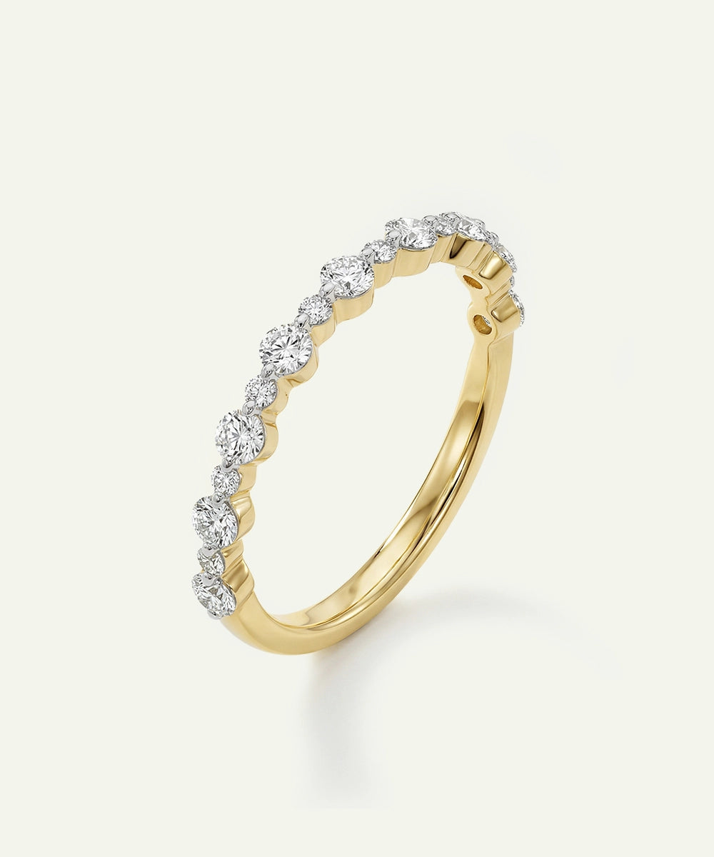Gold ring with diamond accents on a light beige background