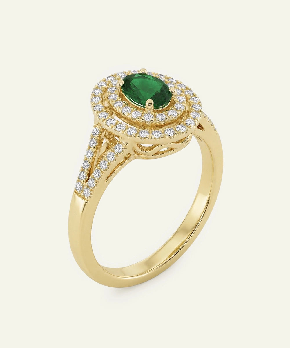 Gold ring with a green gemstone and diamond accents on a white background
