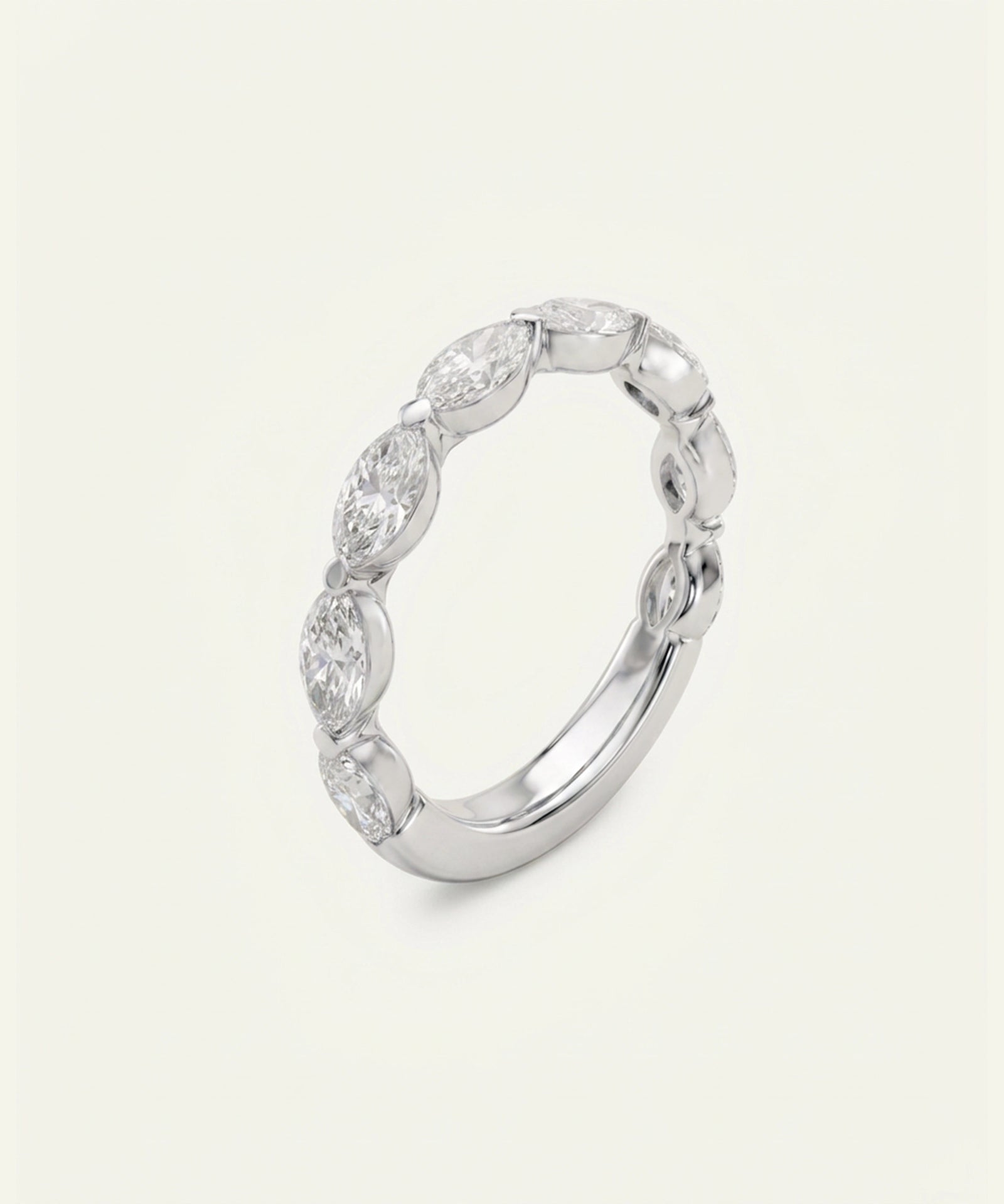 A silver band ring featuring a row of marquise-cut clear gemstones set in a continuous oval shape, photographed on a light cream background.