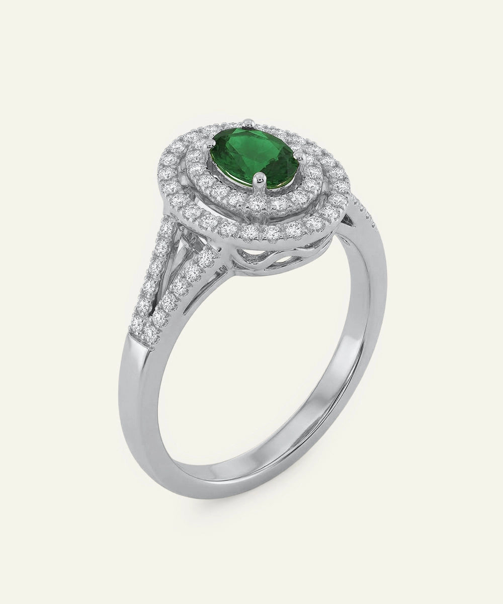 Silver ring with a green gemstone and diamond accents on a white background