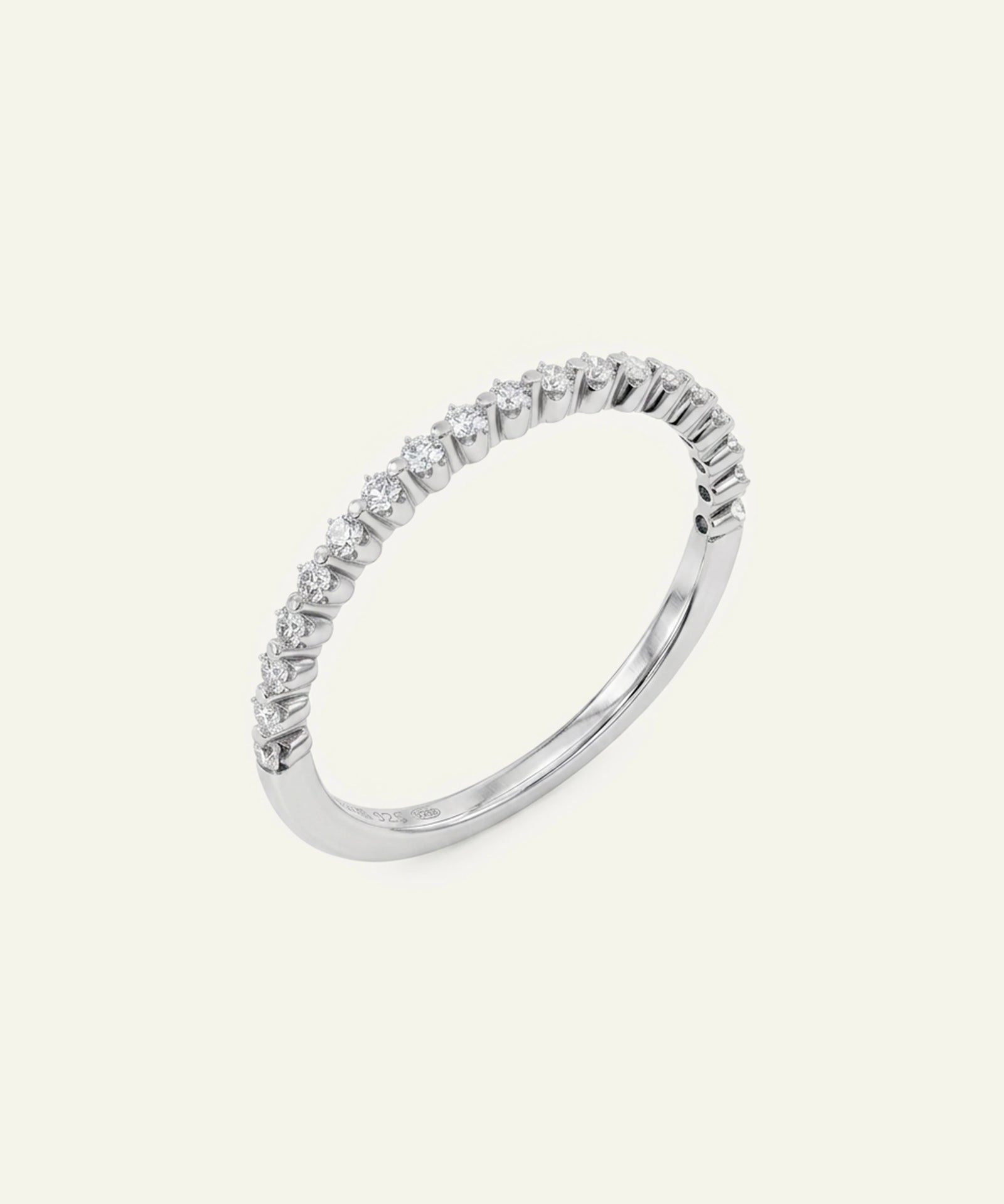 A silver-toned eternity ring featuring a row of small clear round-cut stones, photographed on a solid off-white background.